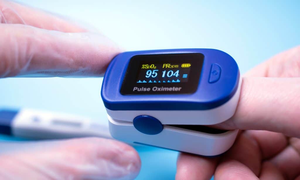 Close up of pulse oximeter on patient finger.